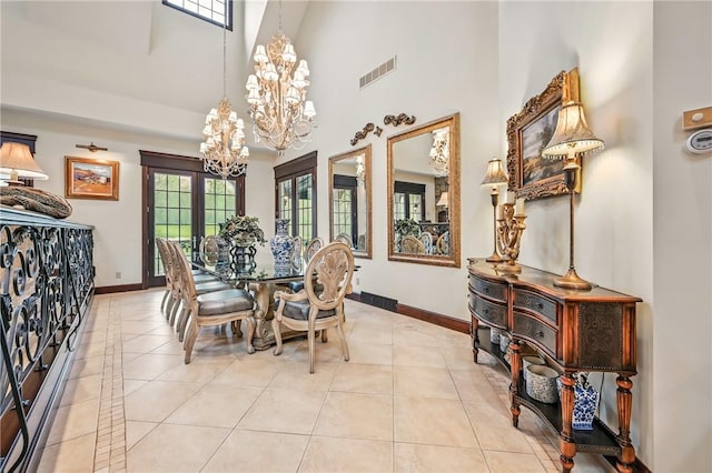 dining area featuring a chandelier, a high ceiling, baseboards, and light tile patterned floors