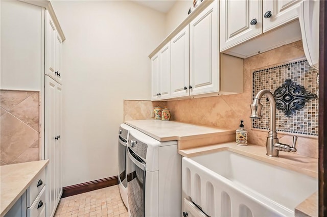 washroom with cabinet space, separate washer and dryer, and baseboards