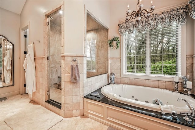 full bathroom featuring a chandelier, a stall shower, a tub with jets, tile walls, and marble finish flooring