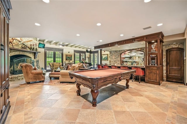 game room featuring billiards table, recessed lighting, a dry bar, a fireplace, and stone tile floors