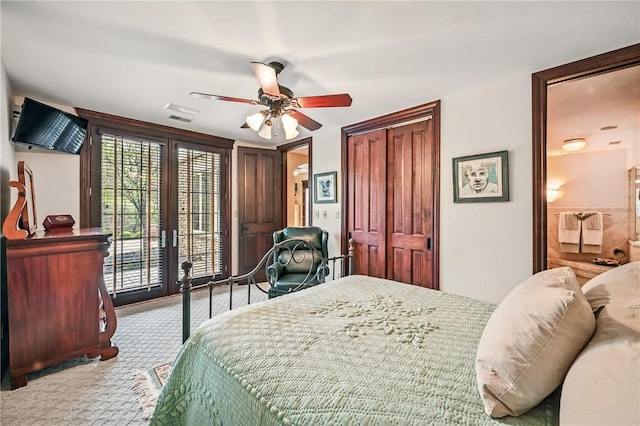 carpeted bedroom featuring access to outside, french doors, a ceiling fan, ensuite bathroom, and a closet