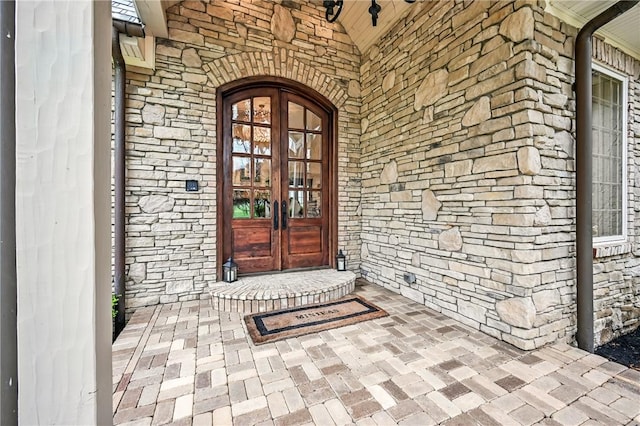 property entrance featuring french doors and stone siding