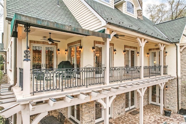 rear view of house with ceiling fan, a balcony, french doors, and a patio