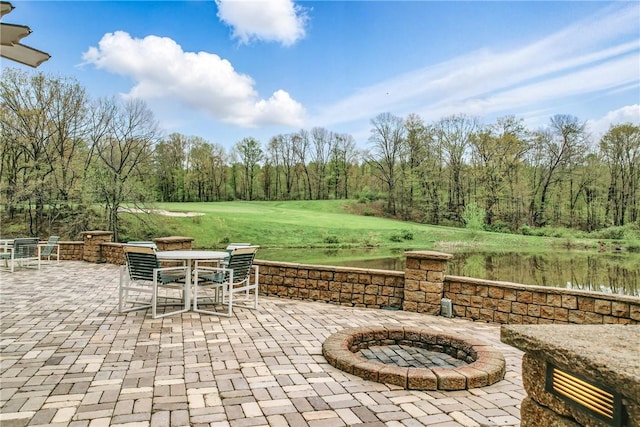 view of patio with a water view and outdoor dining space
