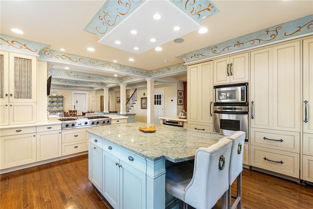 265 Scaife Rd, Sewickley Heights, PA 15143 - kitchen featuring stainless steel appliances, cream cabinets, a center island, dark wood-type flooring, and a peninsula