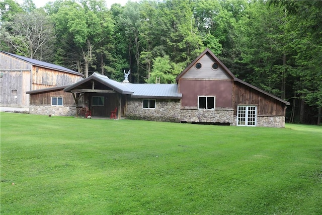 view of front of house featuring stone siding, a front lawn, and metal roof
