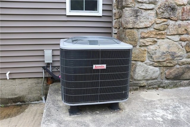 exterior view of central AC unit and stone siding