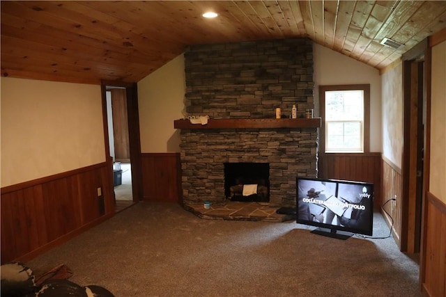 unfurnished living room featuring a wainscoted wall, lofted ceiling, a fireplace, wood ceiling, and carpet flooring