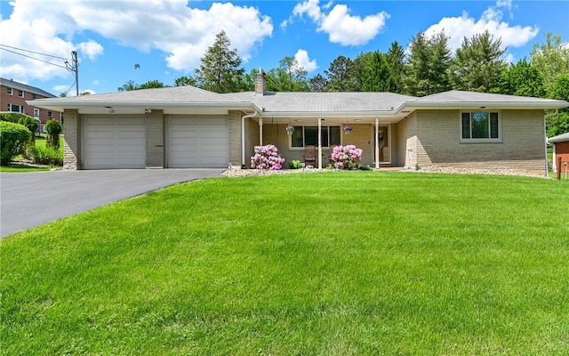 ranch-style home featuring brick siding, a garage, asphalt driveway, and a front lawn