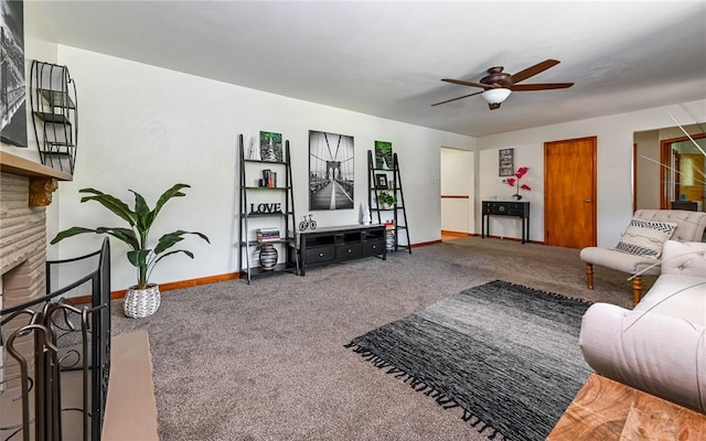 living room with a ceiling fan, carpet floors, baseboards, and a fireplace