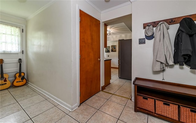 mudroom with light tile patterned flooring, crown molding, and baseboards