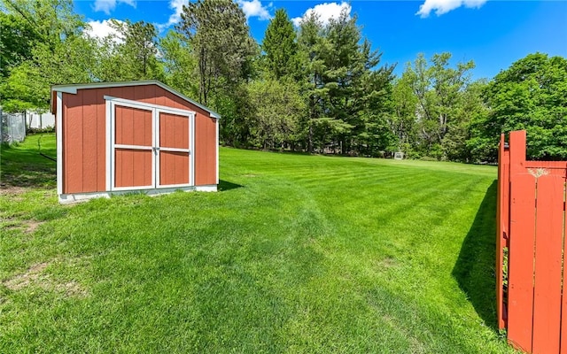 view of green lawn with a shed and an outbuilding