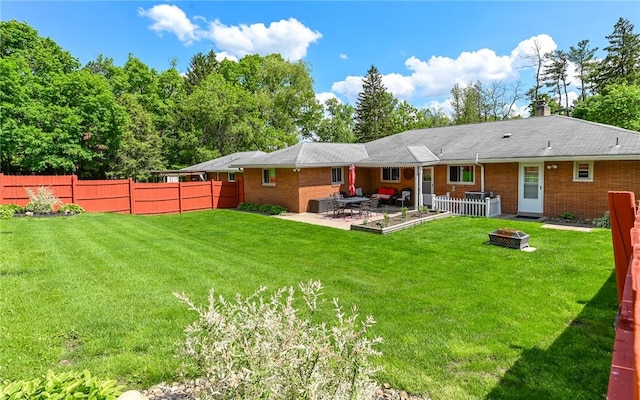 back of house with an outdoor fire pit, a patio area, brick siding, and a chimney