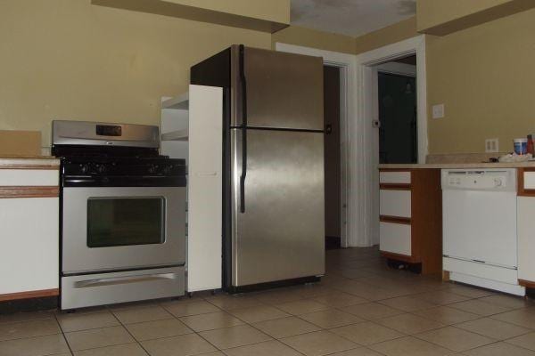 41 Sylvia Ave, Ross Twp, PA 15214 - kitchen with gas range, white dishwasher, freestanding refrigerator, light countertops, and light tile patterned floors