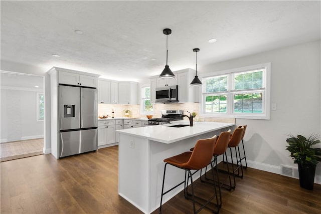 3334 Comanche Rd, Upper St Clair, PA 15241 - kitchen with stainless steel appliances, a sink, a peninsula, a kitchen breakfast bar, and dark wood-style floors