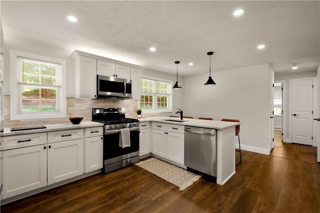 3334 Comanche Rd, Upper St Clair, PA 15241 - kitchen featuring stainless steel appliances, a peninsula, a sink, dark wood-type flooring, and tasteful backsplash