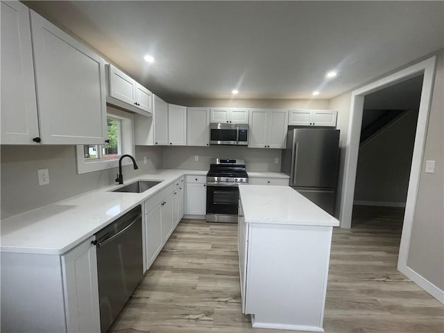 1215 Main St, Bentleyville, PA 15314 - kitchen featuring appliances with stainless steel finishes, a sink, a center island, light wood finished floors, and light countertops