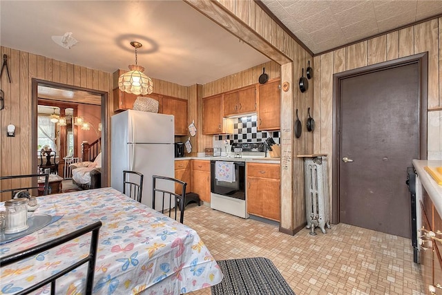 kitchen with freestanding refrigerator, electric range, wooden walls, light countertops, and brown cabinets