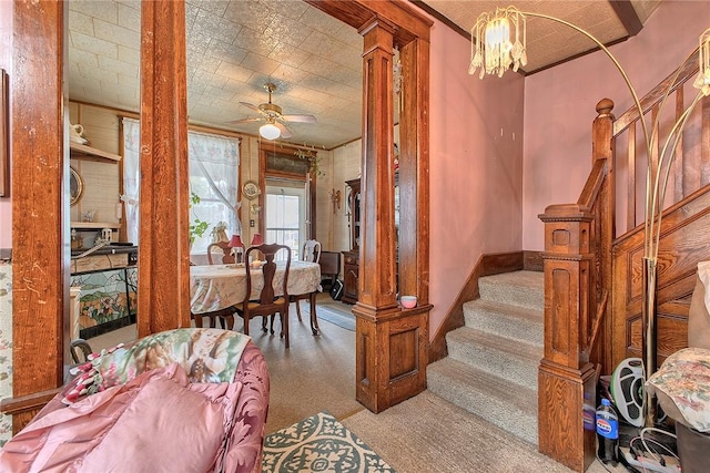 entryway with carpet floors, stairs, a ceiling fan, and a chandelier