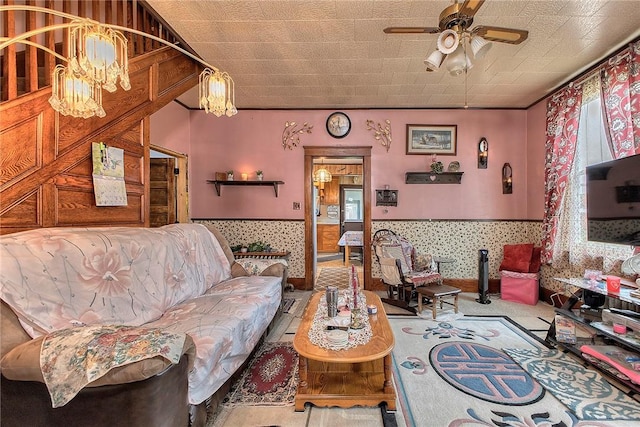 living room with ceiling fan, a chandelier, and wainscoting