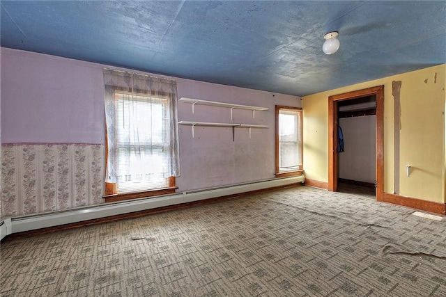 unfurnished bedroom featuring carpet floors, baseboard heating, and multiple windows