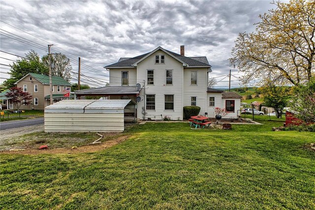257 Lavansville Rd, Somerset Twp, PA 15501 - rear view of house with a chimney, a lawn, a fire pit, and a shingled roof