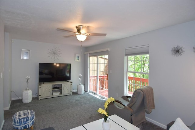 carpeted living room with a ceiling fan and baseboards