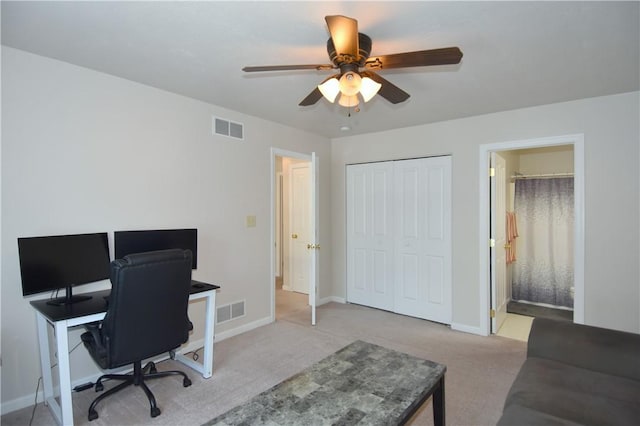 carpeted office with a ceiling fan and baseboards