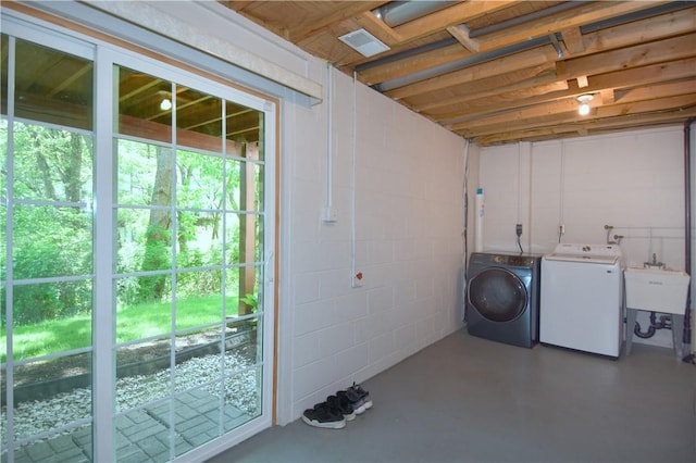 laundry room with independent washer and dryer and concrete block wall