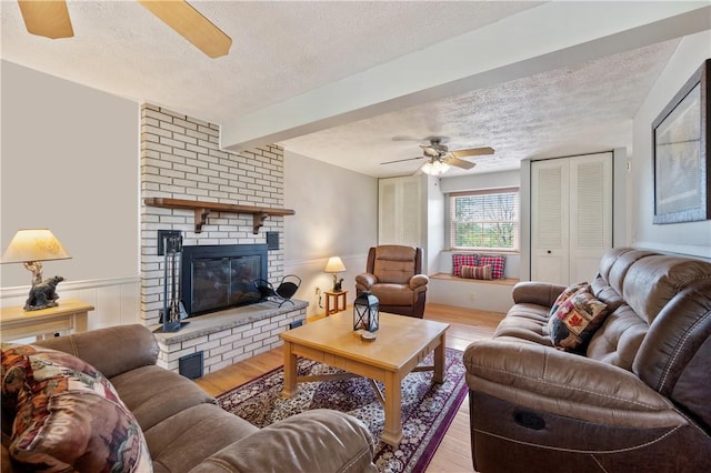 3 Patricia St, Fallowfield, PA 15022 - living area featuring a ceiling fan, a textured ceiling, light wood-style flooring, a brick fireplace, and beam ceiling