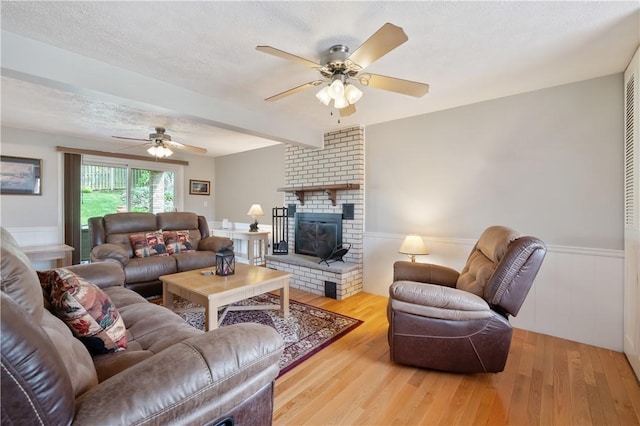 3 Patricia St, Fallowfield, PA 15022 - living room with ceiling fan, wood finished floors, a wainscoted wall, a brick fireplace, and a textured ceiling