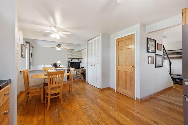 3 Patricia St, Fallowfield, PA 15022 - dining space with a ceiling fan, a brick fireplace, light wood finished floors, stairway, and baseboards