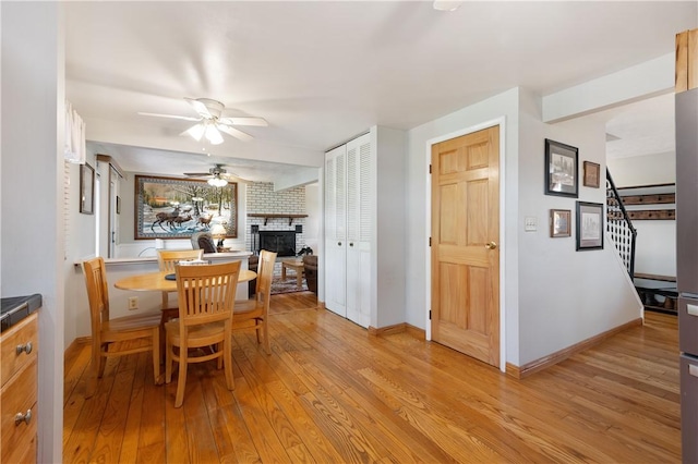 3 Patricia St, Fallowfield, PA 15022 - dining area with ceiling fan, a brick fireplace, light wood-style flooring, stairs, and baseboards
