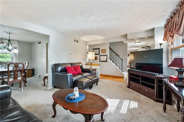 3 Patricia St, Fallowfield, PA 15022 - carpeted living room featuring a textured ceiling, stairs, a chandelier, and baseboards