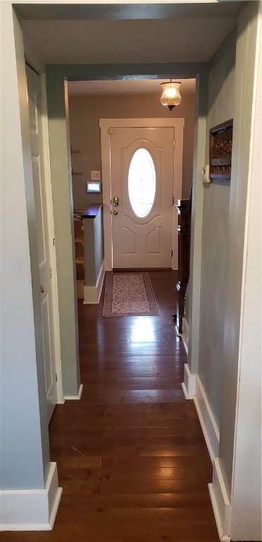 doorway to outside with wood finished floors and baseboards