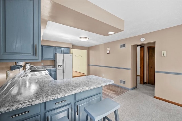 2918 Woodland Cir, Hampton, PA 15101 - kitchen featuring white refrigerator with ice dispenser, a sink, blue cabinetry, and baseboards