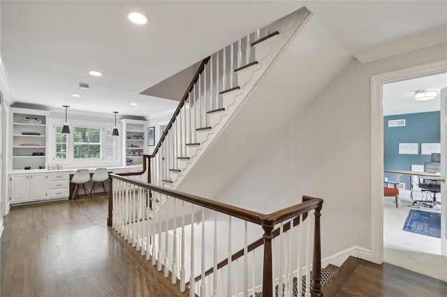staircase with wood finished floors, built in desk, recessed lighting, and baseboards