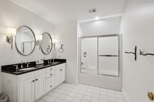full bath featuring baseboards, double vanity, enclosed tub / shower combo, and tile patterned floors