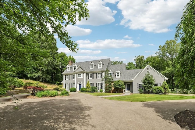 view of front of house featuring a chimney and a front yard