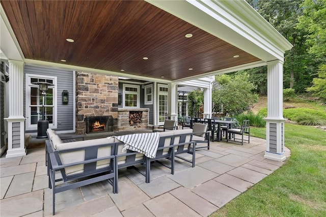 view of patio featuring an outdoor stone fireplace and outdoor dining space