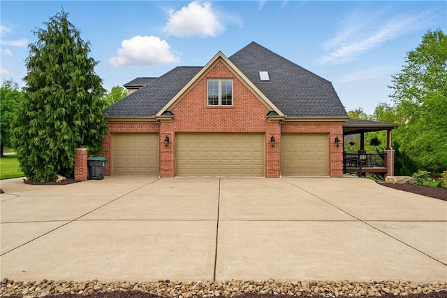 view of front of property featuring driveway, brick siding, and a shingled roof
