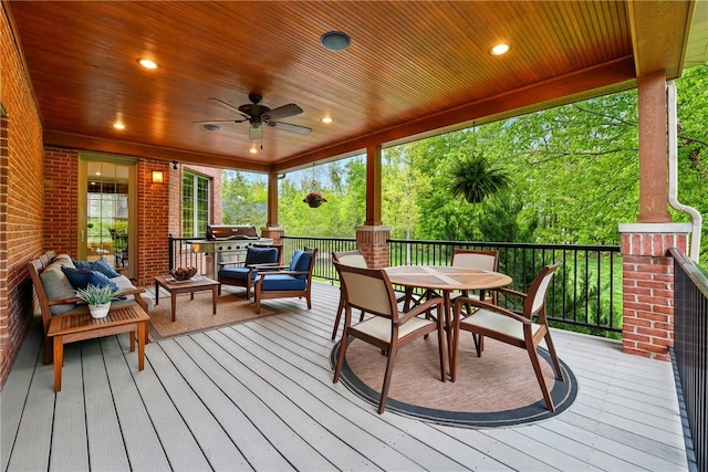 wooden terrace featuring outdoor dining area, ceiling fan, and an outdoor hangout area