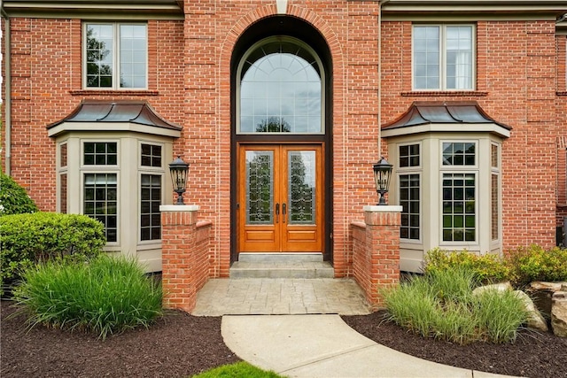 property entrance featuring french doors and brick siding