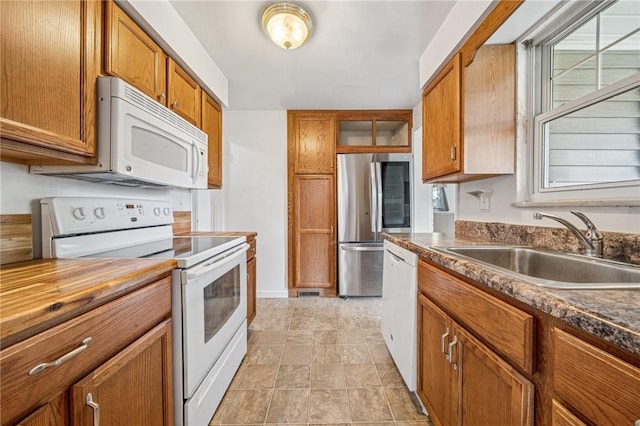 339 Hamil Rd, Penn Hills, PA 15147 - kitchen with white appliances, a sink, and brown cabinetry