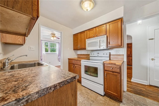 339 Hamil Rd, Penn Hills, PA 15147 - kitchen featuring white appliances, a sink, arched walkways, brown cabinetry, and ceiling fan