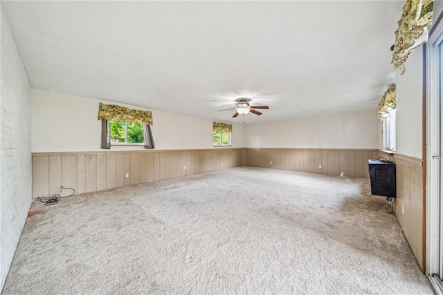 339 Hamil Rd, Penn Hills, PA 15147 - carpeted spare room featuring a wood stove, a ceiling fan, a wainscoted wall, and wooden walls