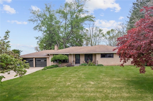 view of front of home featuring a garage, a front lawn, driveway, a chimney, and brick siding