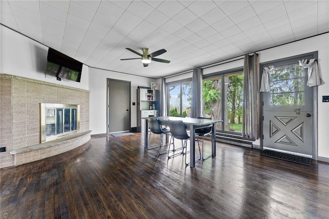 dining area featuring wood finished floors, a ceiling fan, and baseboards