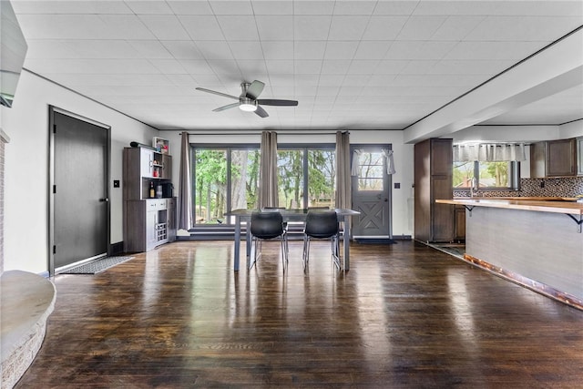 living room with a ceiling fan, dark wood-style floors, and baseboards