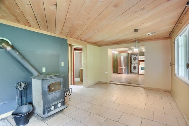 138 Bovard Ln, Cherry Twp, PA 16020 - unfurnished living room featuring stacked washer / dryer, a wood stove, and wooden ceiling